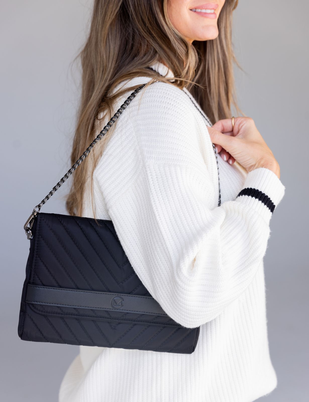 Quilted clutch worn with chain strap
